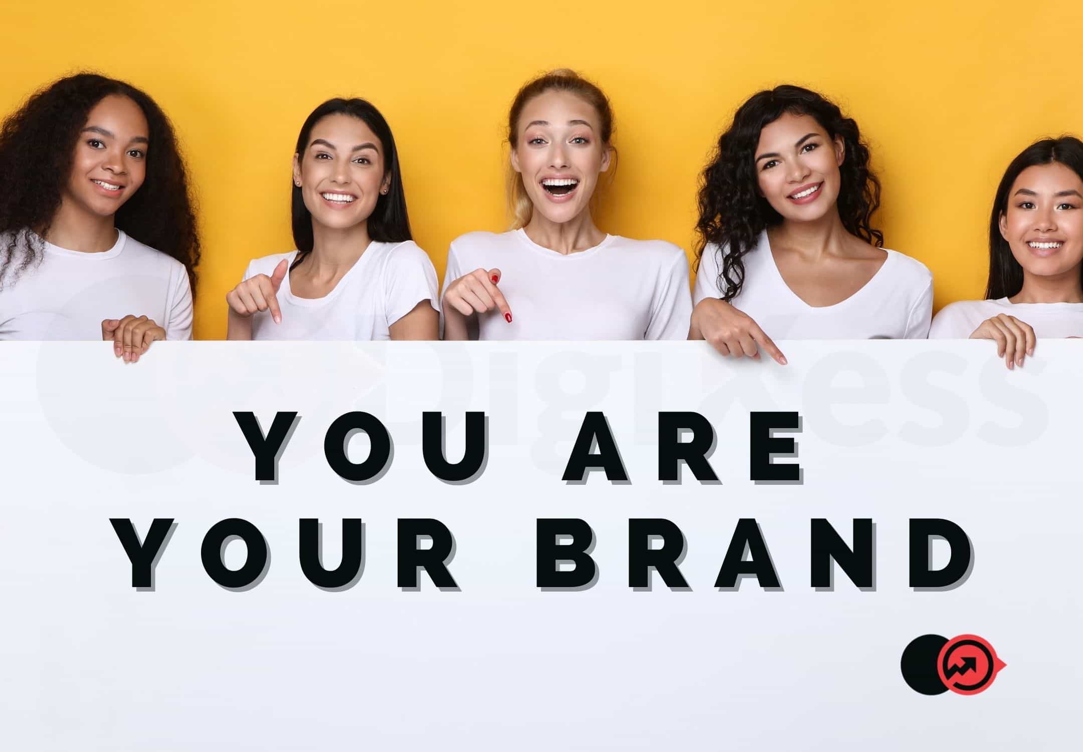 Women Holding a board with the text: you are your brand.